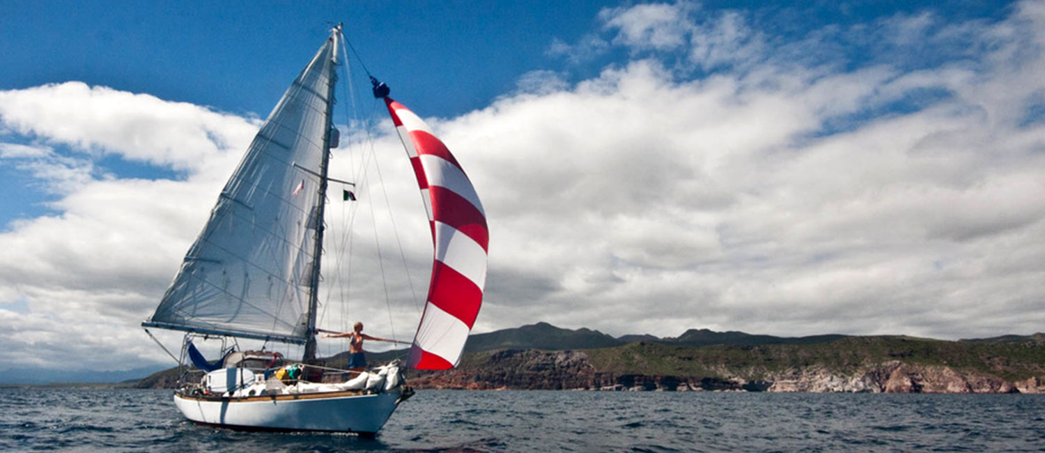 The Rascal rolling down hill with her spinnaker out in the Sea of Cortez
